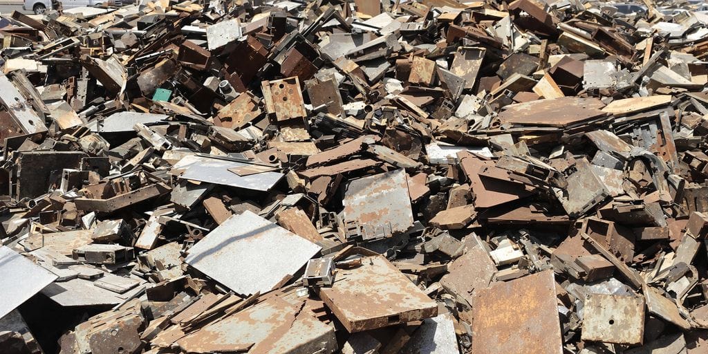 صورة فوتوغرافية لعناصر خردة معدنية متناثرة في ساحة صناعية بمكة